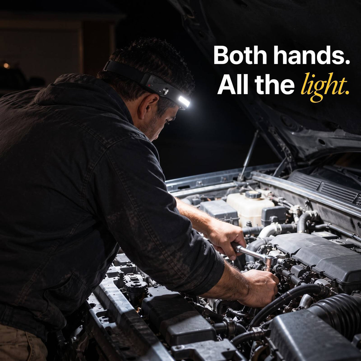A man working under a car hood with both hands, the engine bay lit by the Arc headlamp